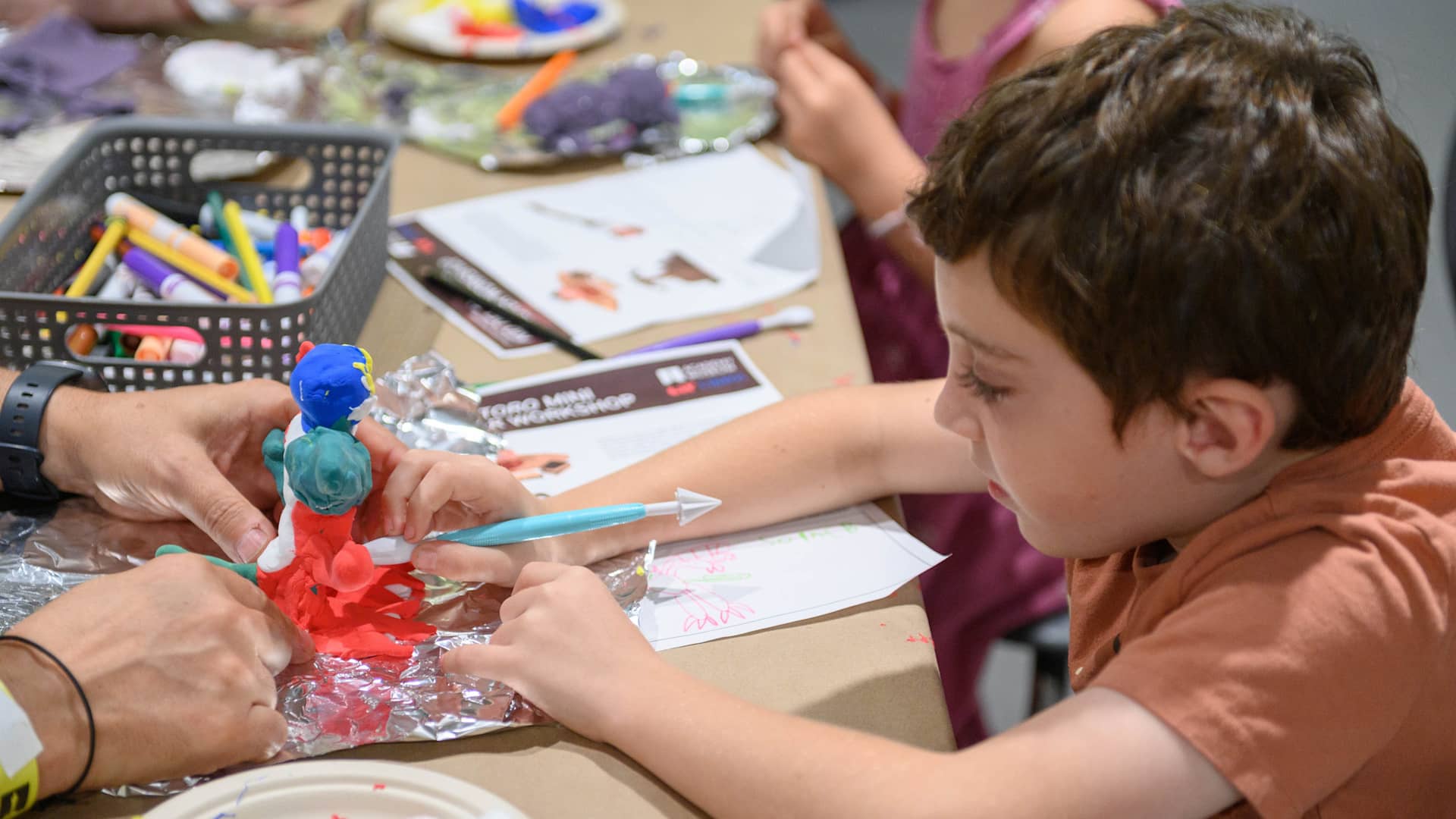 Child at Academy Museum making clay figurine