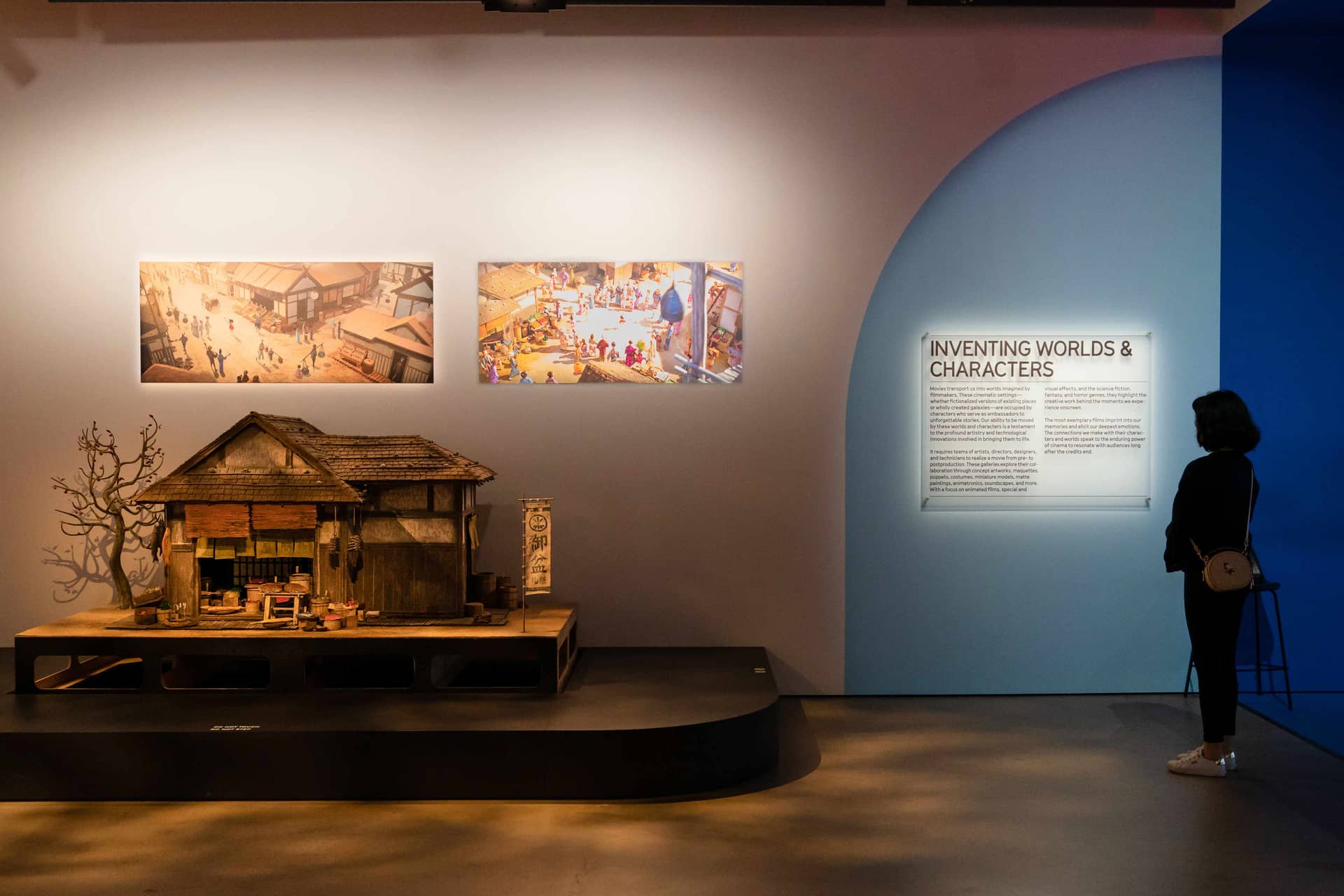 Women reading wall text and looking at model