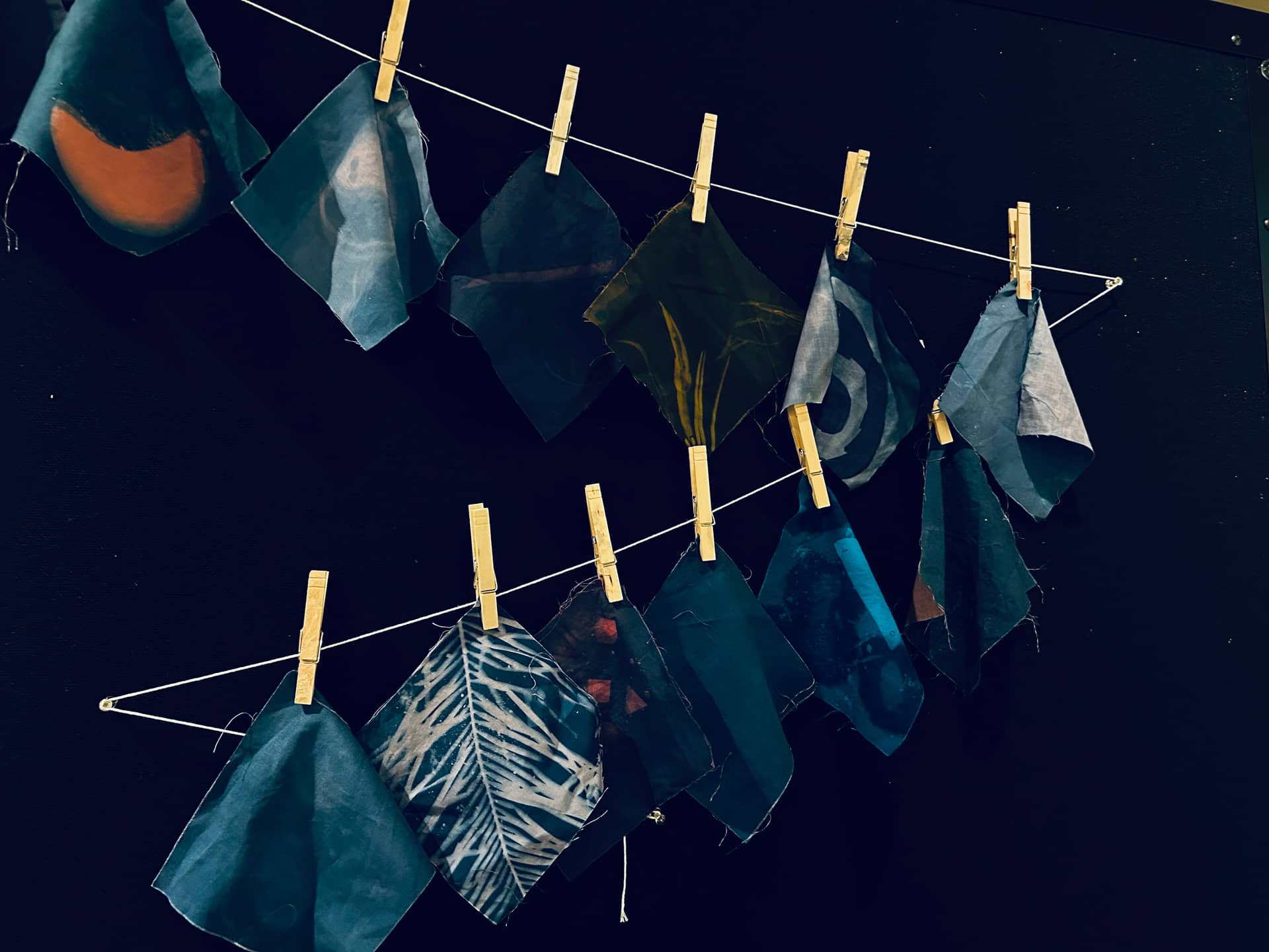 Blue cloth hanging on a clothesline with clothespins.