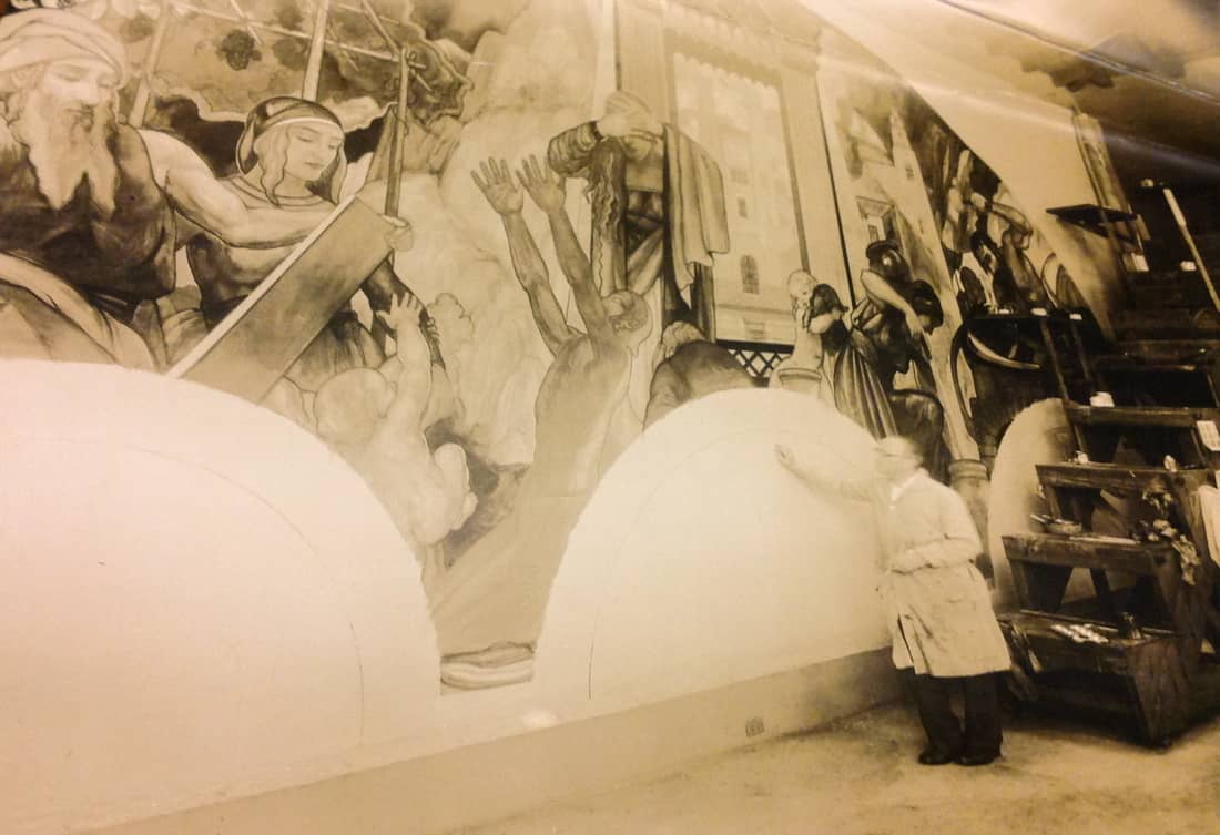 Hugo Ballin in his Pacific Palisades studio showing a section of the Western Lunette depicting the Messianic Age and demonstrating the scale of his work––note the movable steps to the right which enables him to reach the top, Ballin Archives, UCLA Special Collections.