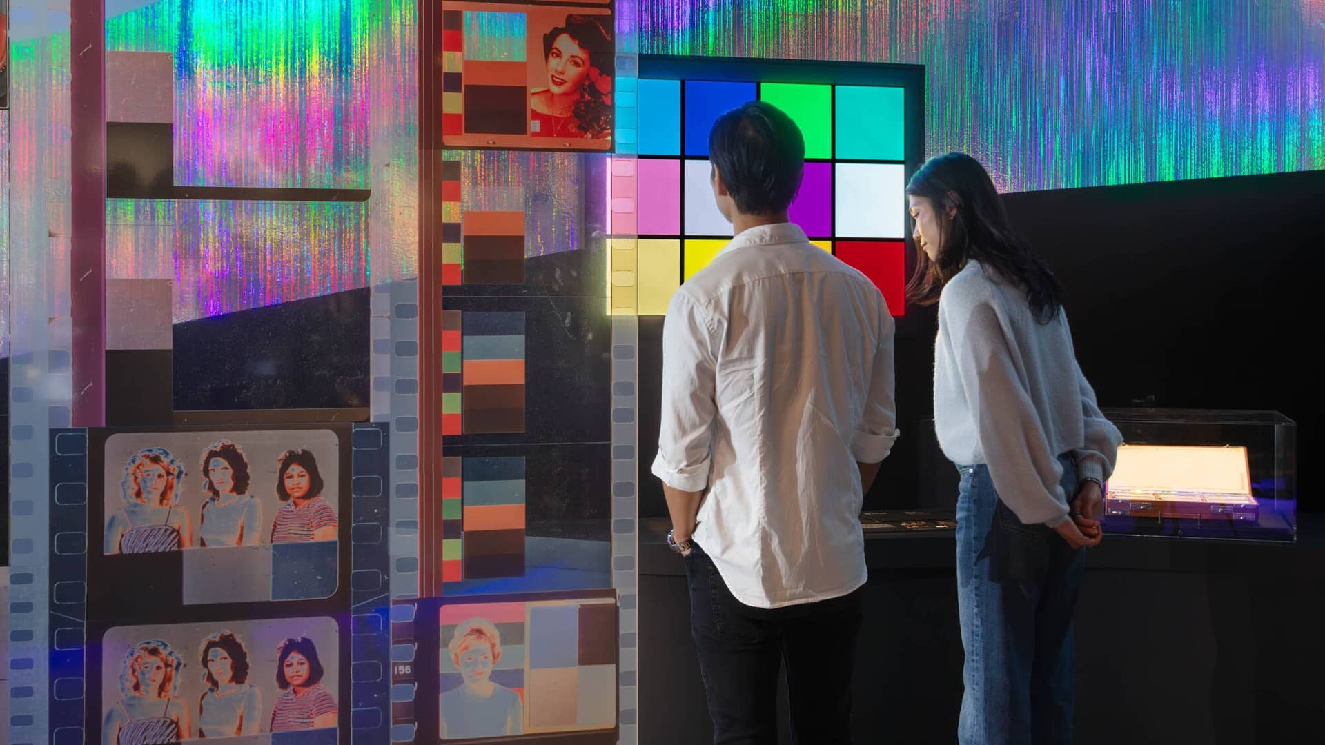 Two individuals looking at a color diorama in a museum gallery